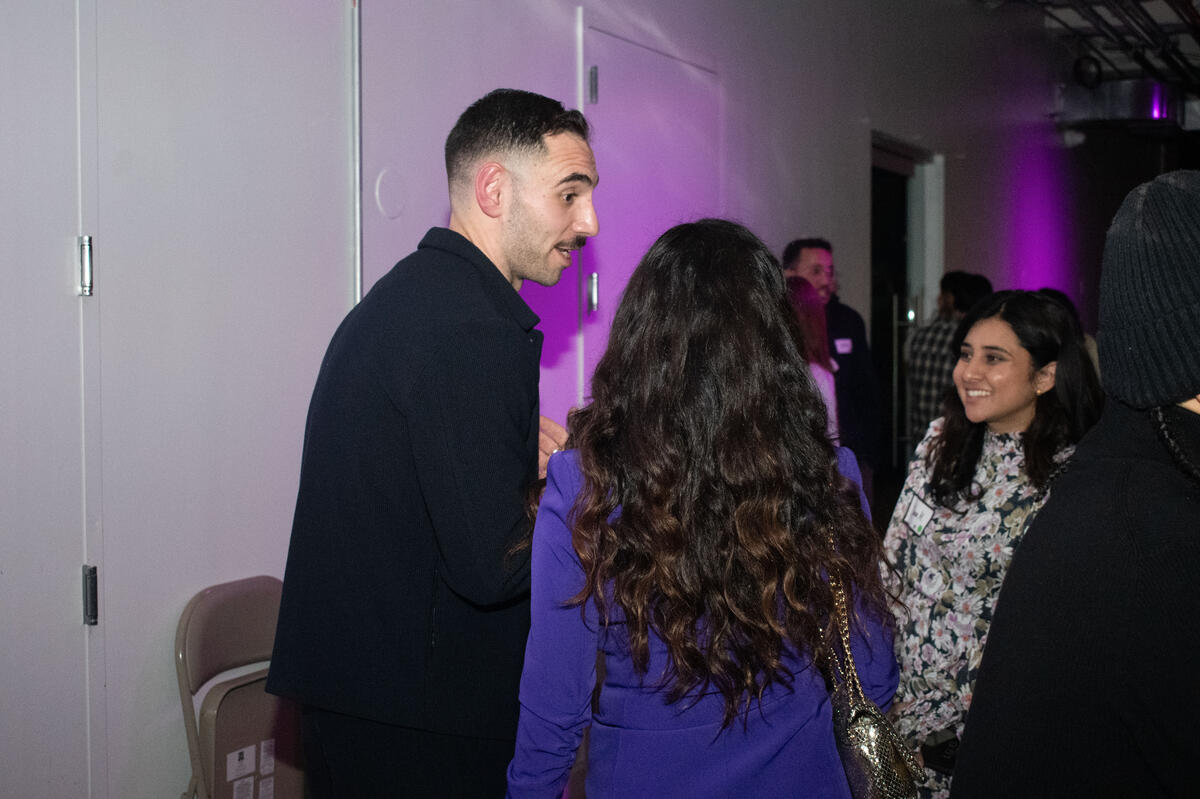 Zaid Fouzi talking with guests at Habibi In The City, purple lighting