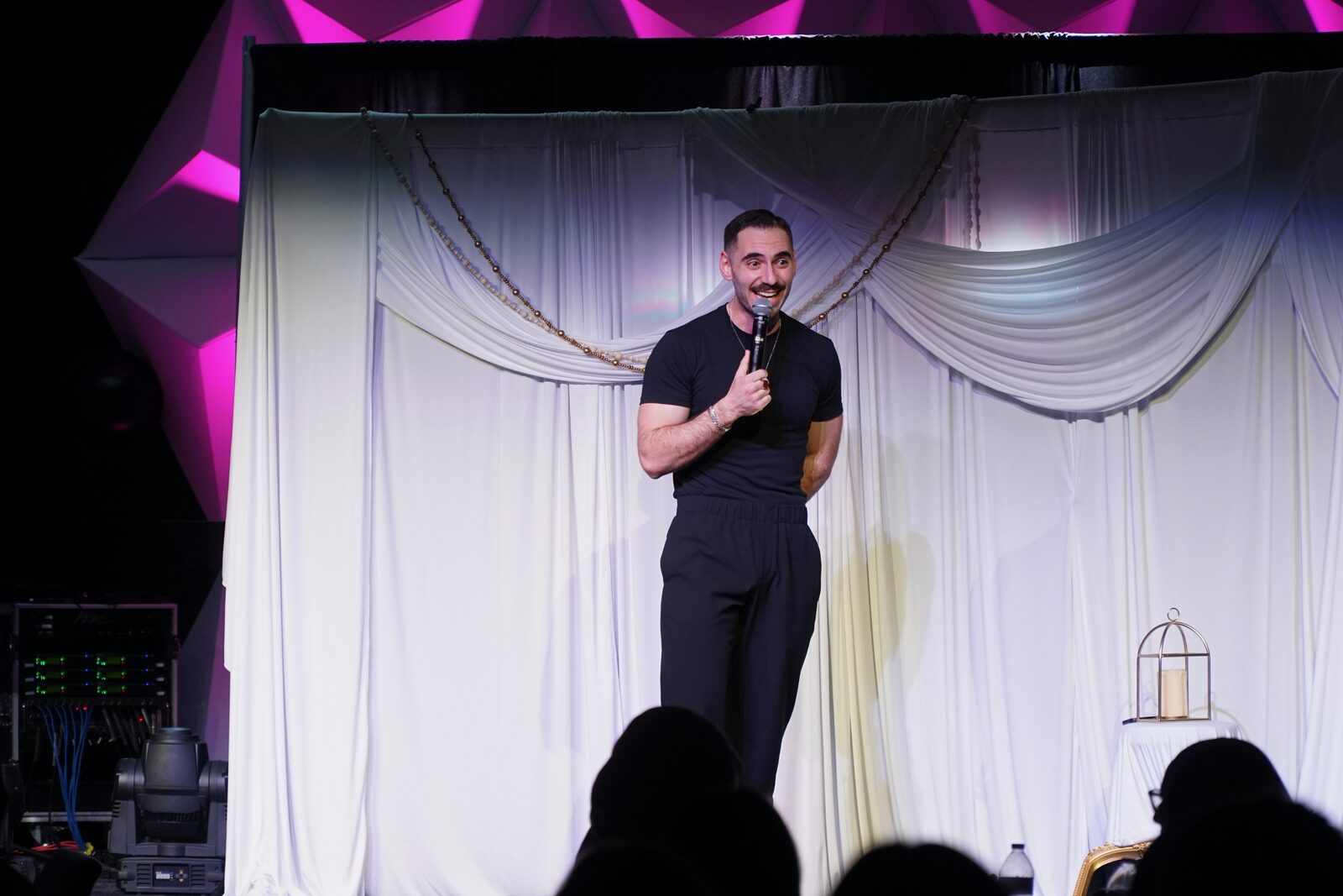 Zaid Fouzi laughing on stage at OU Arab Students Comedy Night, Norman OK