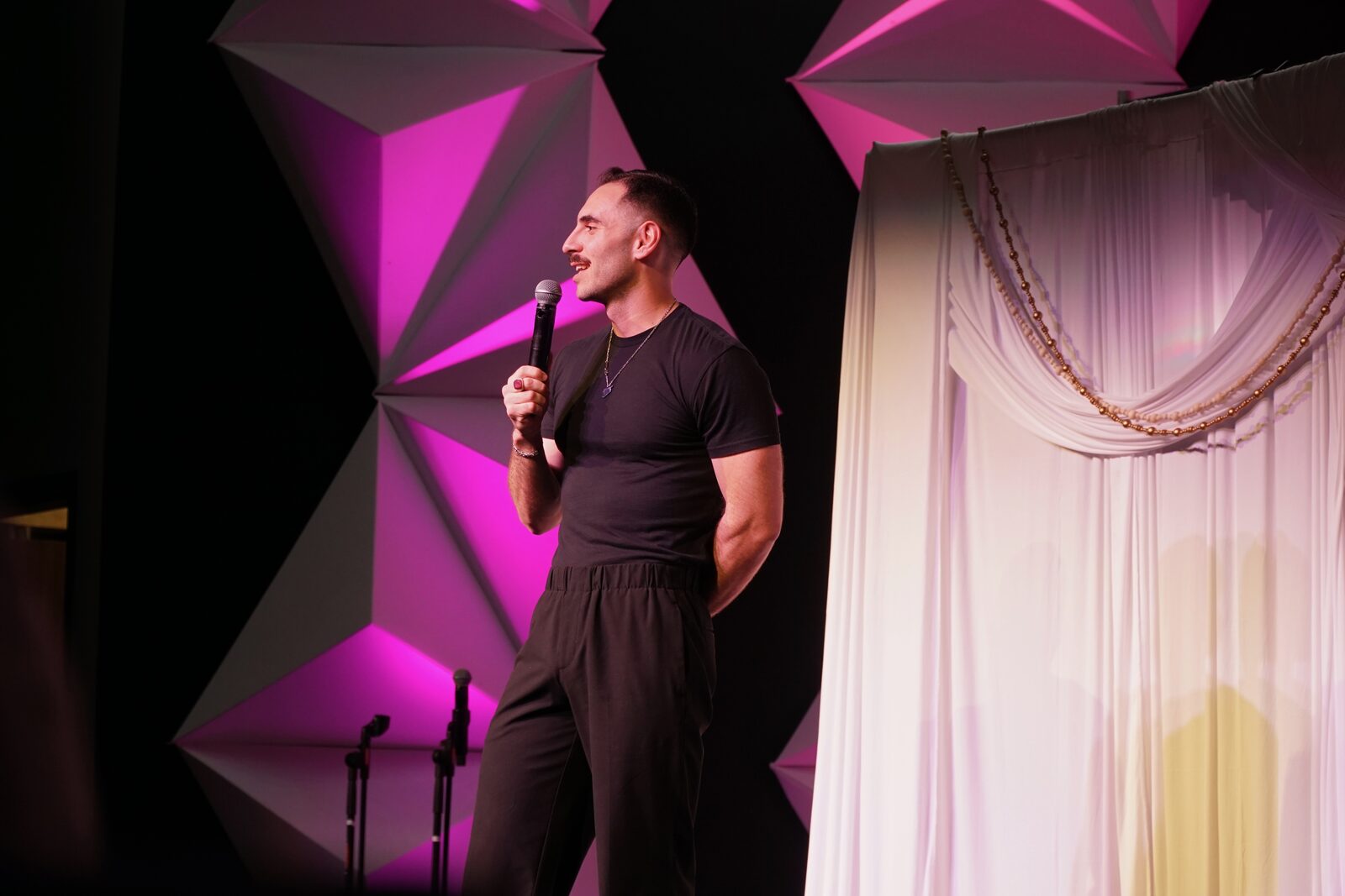 Zaid Fouzi clapping mid-set at OU Arab Students Comedy Night, Norman OK