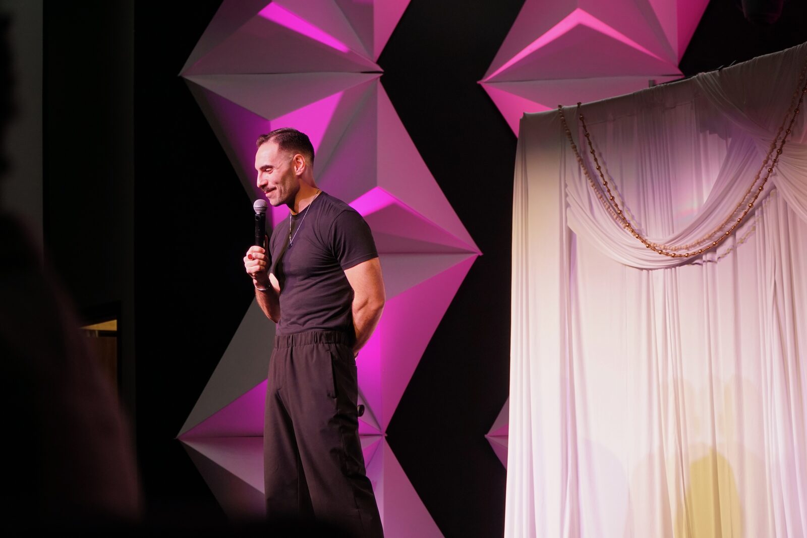 Zaid Fouzi smiling on stage at OU Arab Students Comedy Night, Norman OK