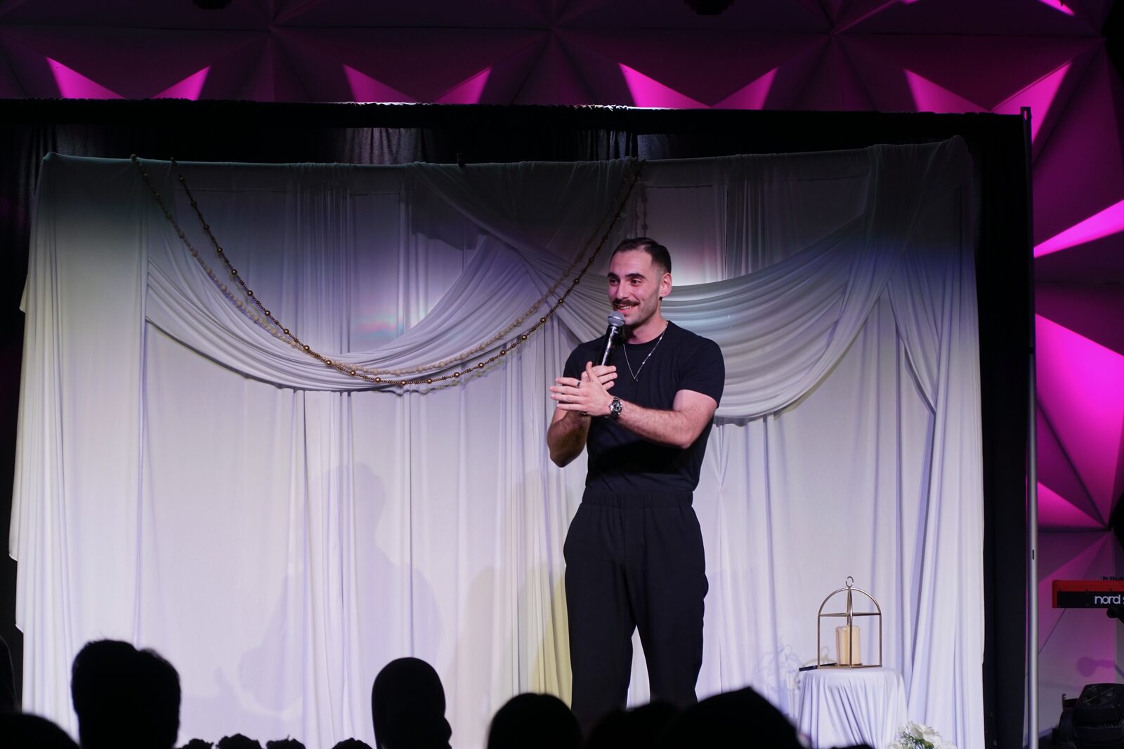 Zaid Fouzi smiling on stage at OU Arab Students Comedy Night, Norman OK