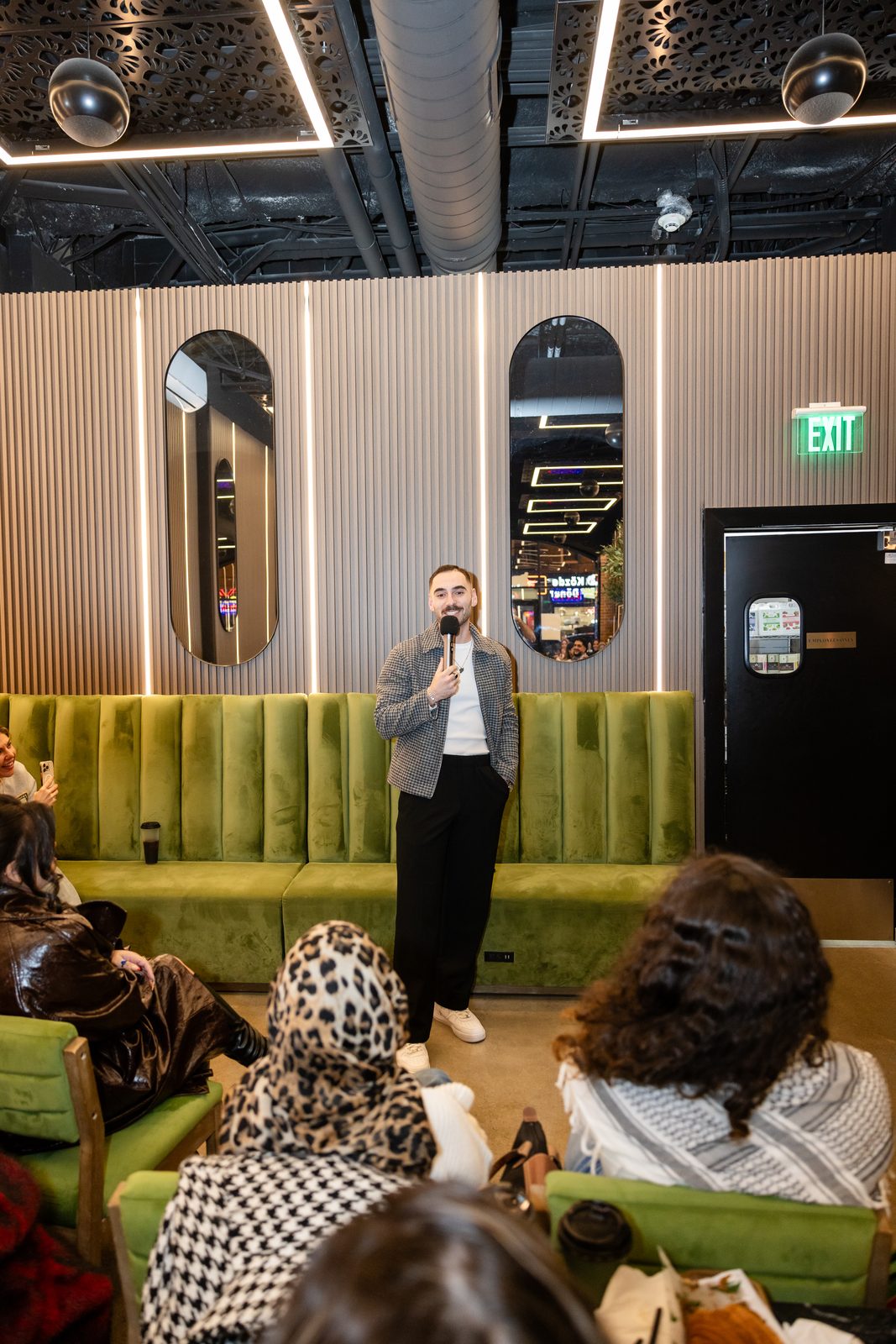 Zaid Fouzi mid-set with audience in foreground at Cafe Comedy Tour, Mokafe Paterson NJ